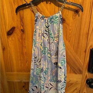 Lilly Pulitzer shirt with gold chain detail around the neck.